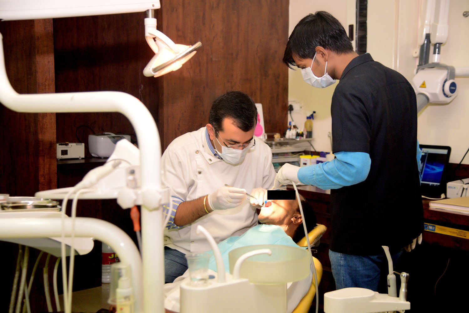 Dr Premdeep Gandhi performing surgical procedure in clinic operatory
