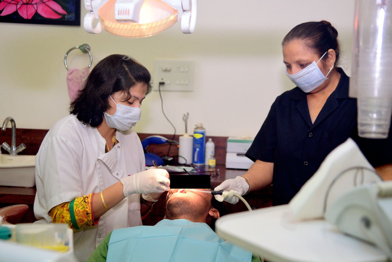 Dr Shikha Gandhi caring for patient in operatory with clinical assistant